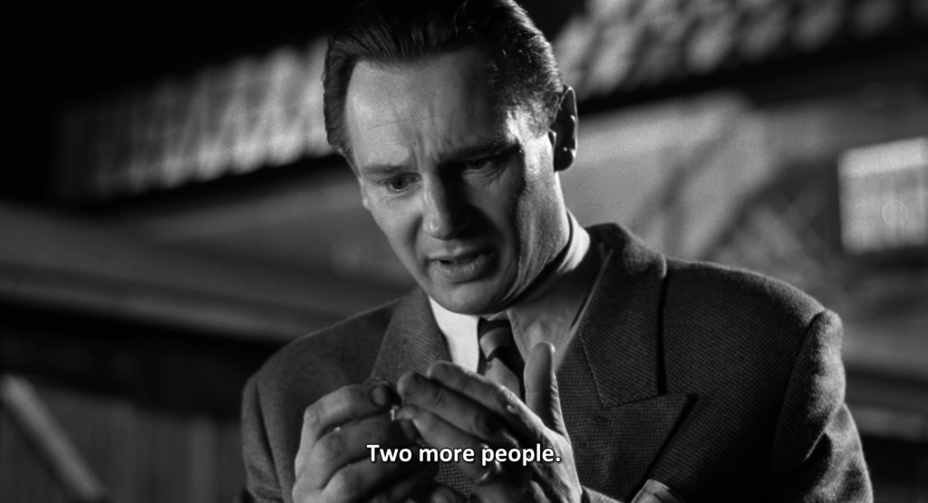 A shot from the end of Schindler's List showing Oskar Schindler looking at his hands and saying "Two more people."